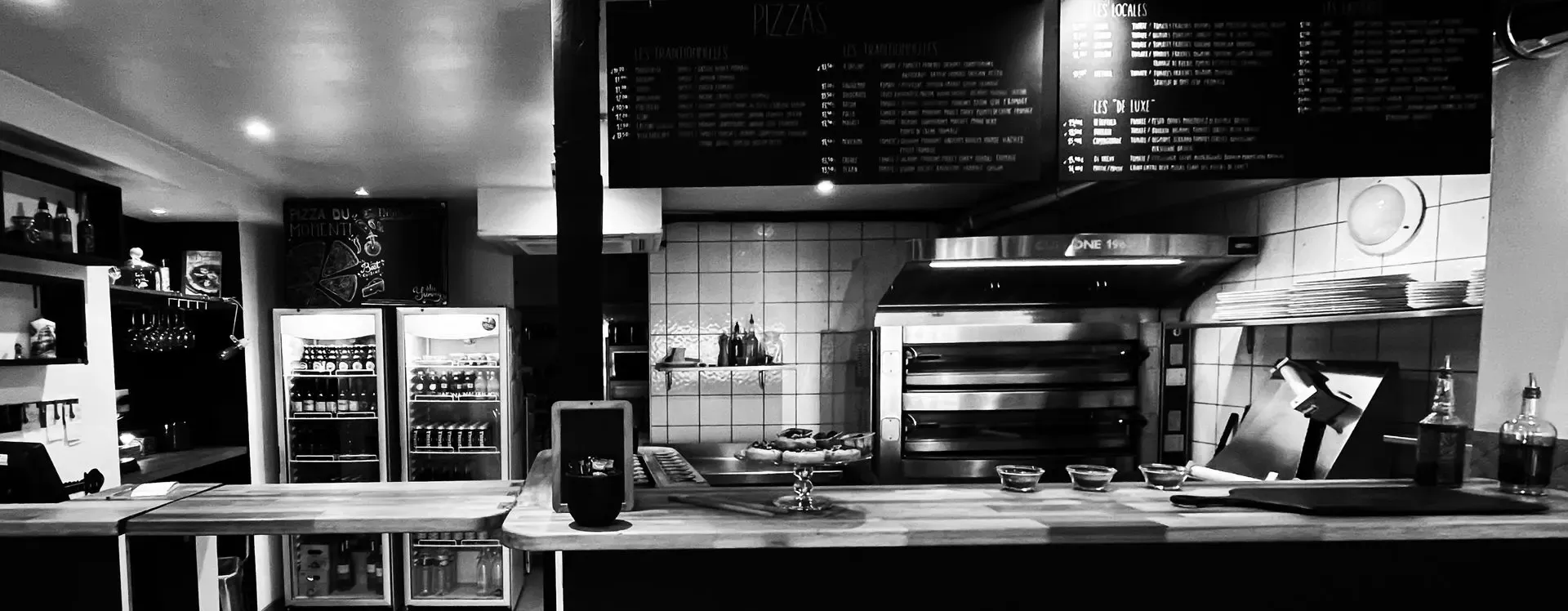 Le comptoir de Pizz'After Beach à Anglet : ardoises de la carte, four à pizza, frigos à boissons